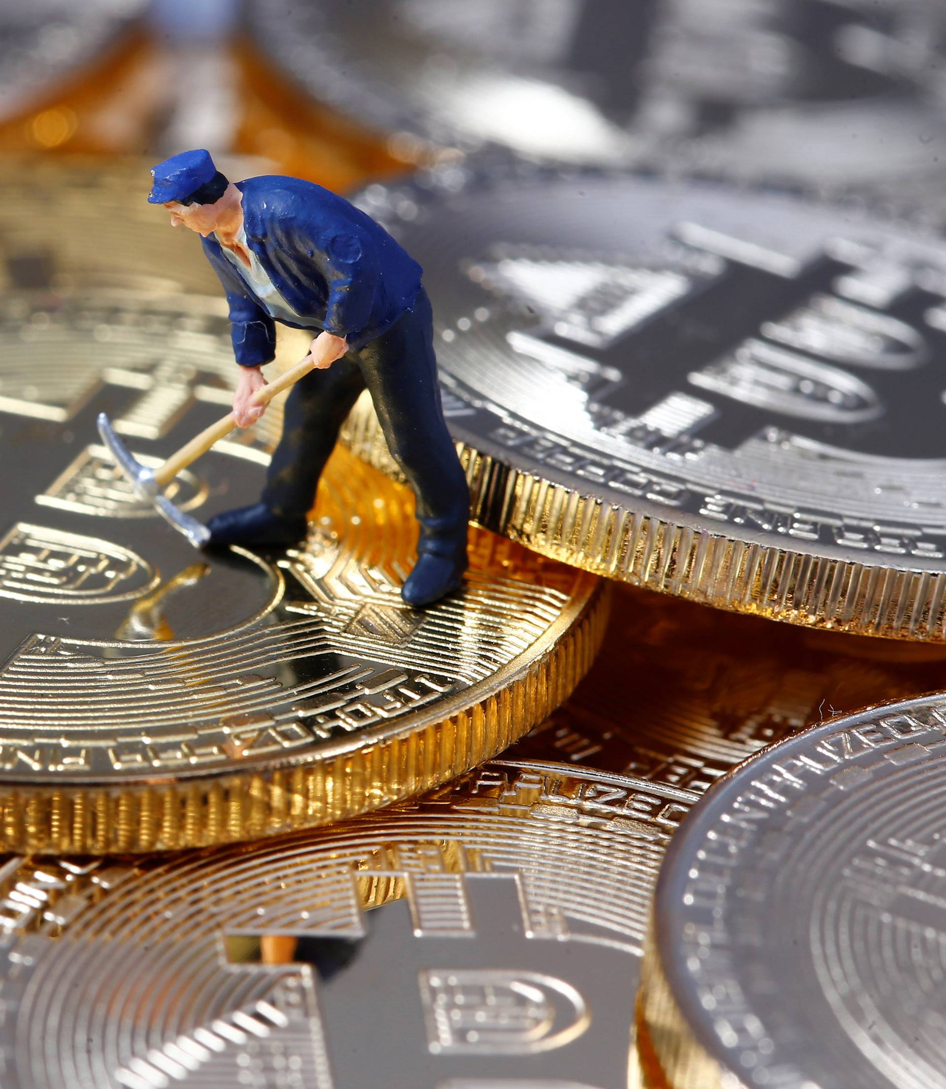 A small toy figure is seen on representations of the Bitcoin virtual currency in this illustration picture