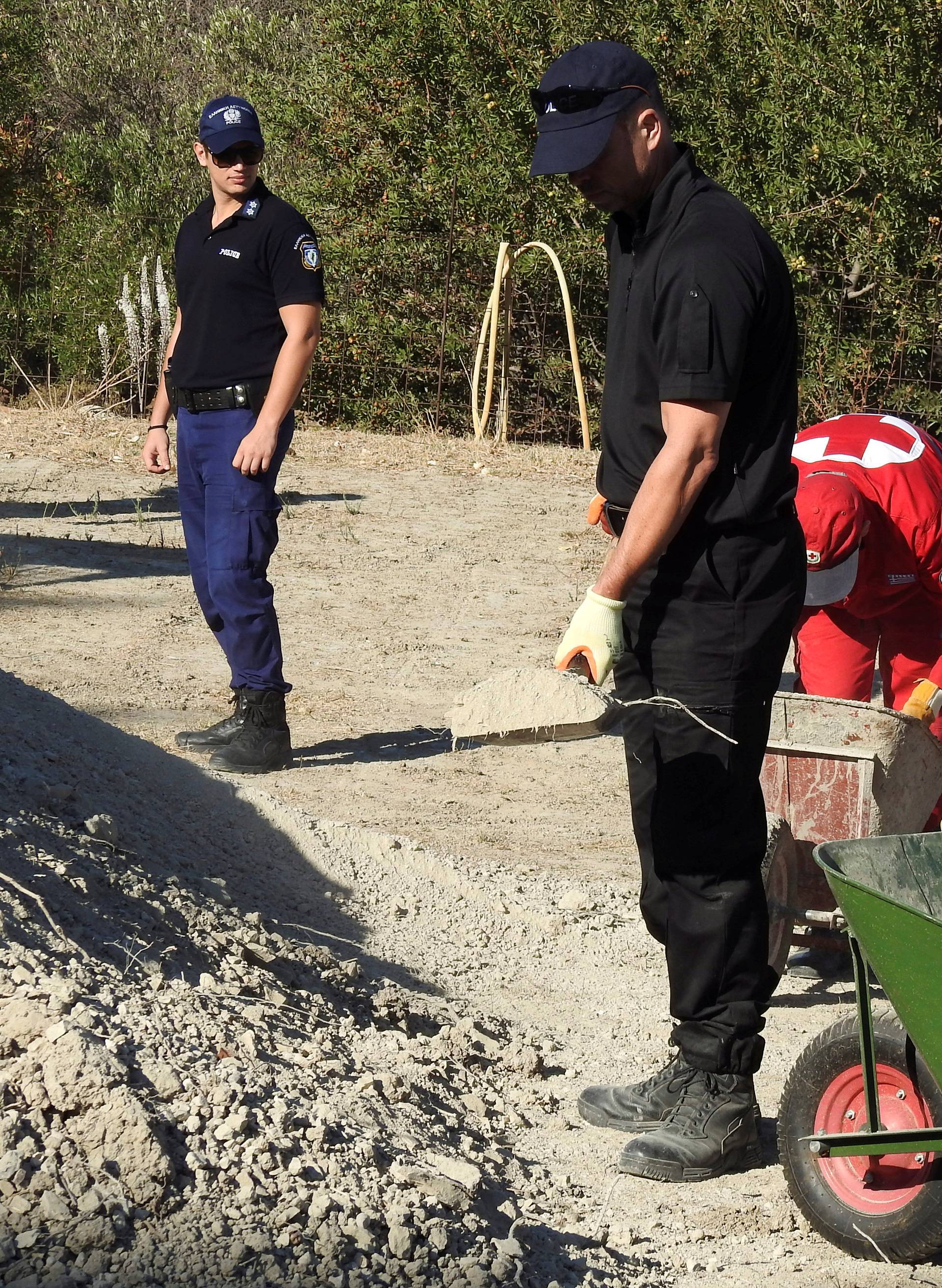 South Yorkshire police officers and members of the Greek rescue service investigate the ground while excavating a site during an investigation for Ben Needham on the island of Kos