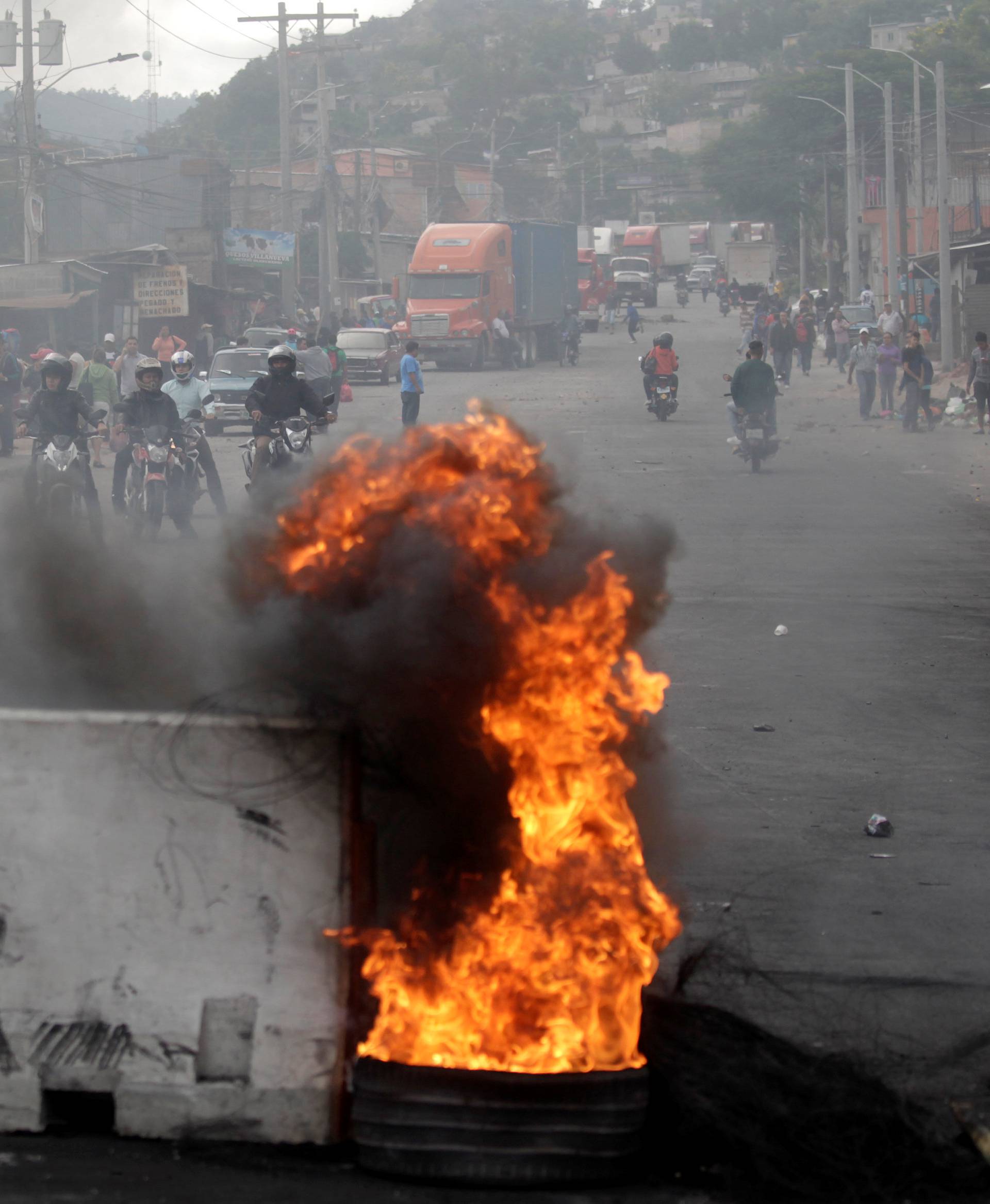 Burning barricade settled to block road by supporters of Nasralla is pictured during a protest caused by the delayed vote count for the presidential election in Tegucigalpa