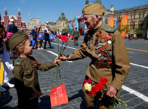 A veteran recives a red rose from a girl during the Victory Day celebrations at the Red Square in Moscow