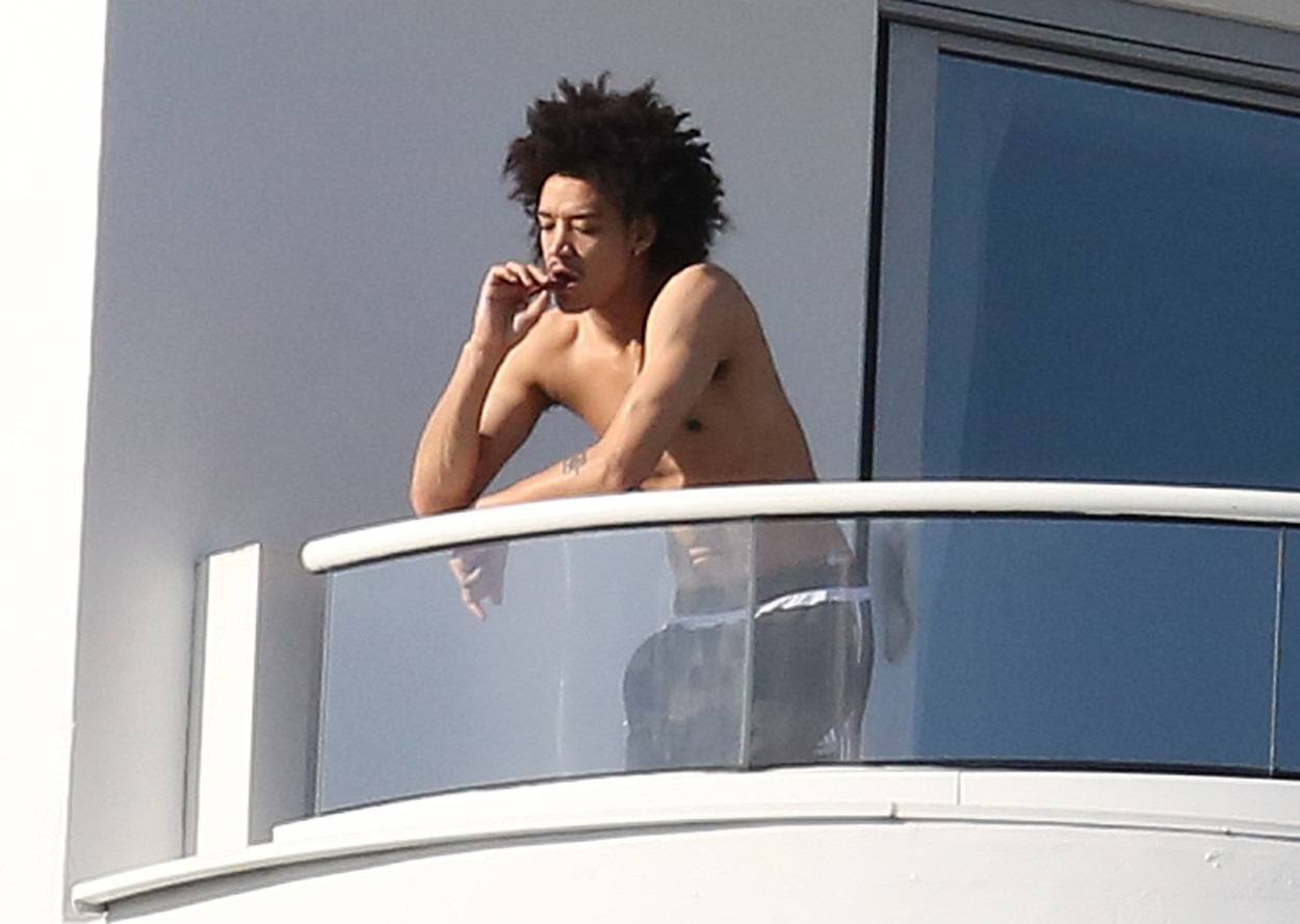 Madonna's rumored boyfriend, 26 year old dancer Ahlamalik Williams, rolls and smokes his own cigarette on their balcony in Miami