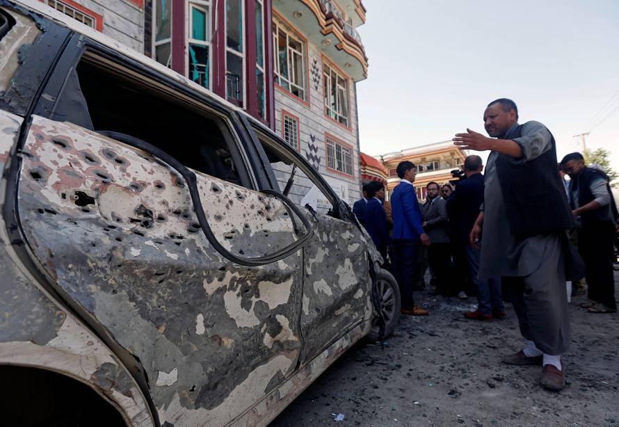 Afghan men inspect the site of a suicide bomb blast in Kabul