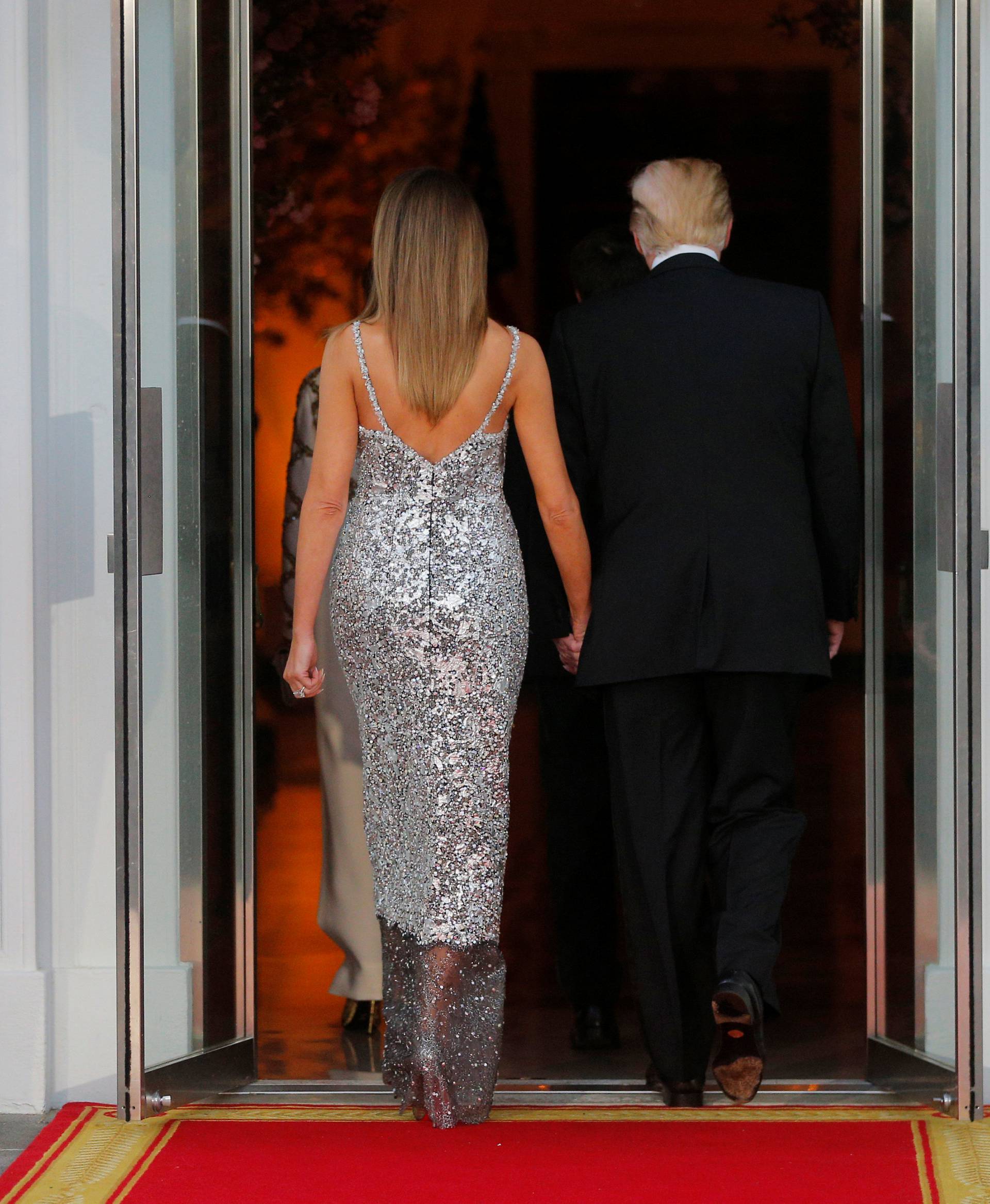 U.S. President Trump and first lady Melania walk into the White House after welcoming French President Macron and his wife for a State Dinner in Washington