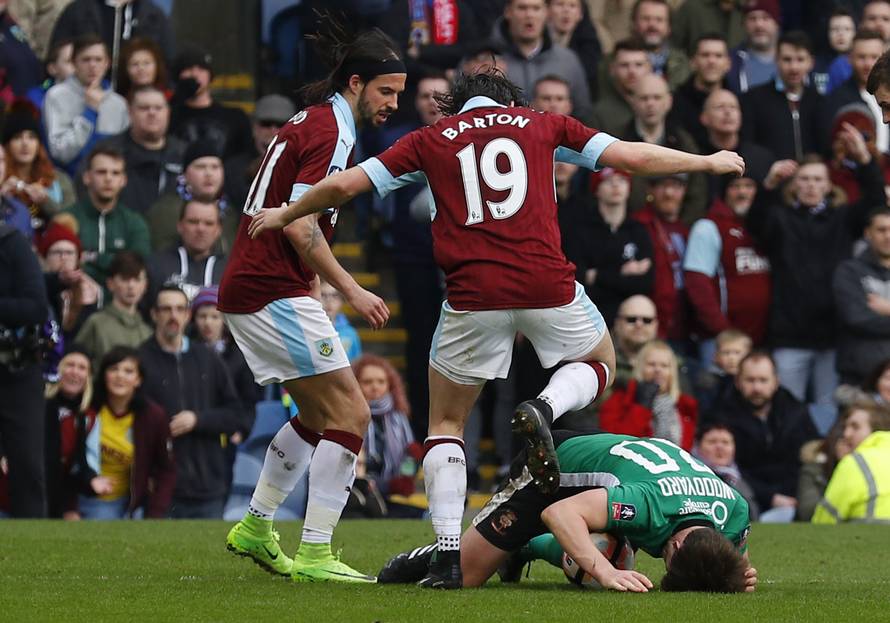 Burnley's Joey Barton clashes with Lincoln's Alex Woodyard as George Boyd looks on