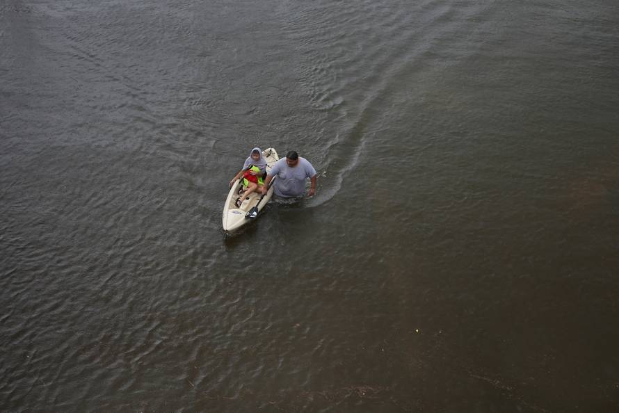 Jesus Rodriguez rescues Gloria Garcia after rain from Hurricane Harvey flooded Pearland, in the outskirts of Houston, Texas