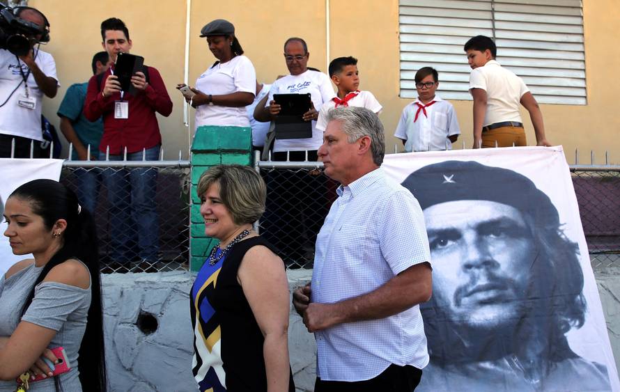 FILE PHOTO: Cuba's First Vice-President Miguel Diaz-Canel and his wife Lis Cuesta stand in line before Diaz-Canel casts his vote during an election of candidates for the national and provincial assemblies, in Santa Clara