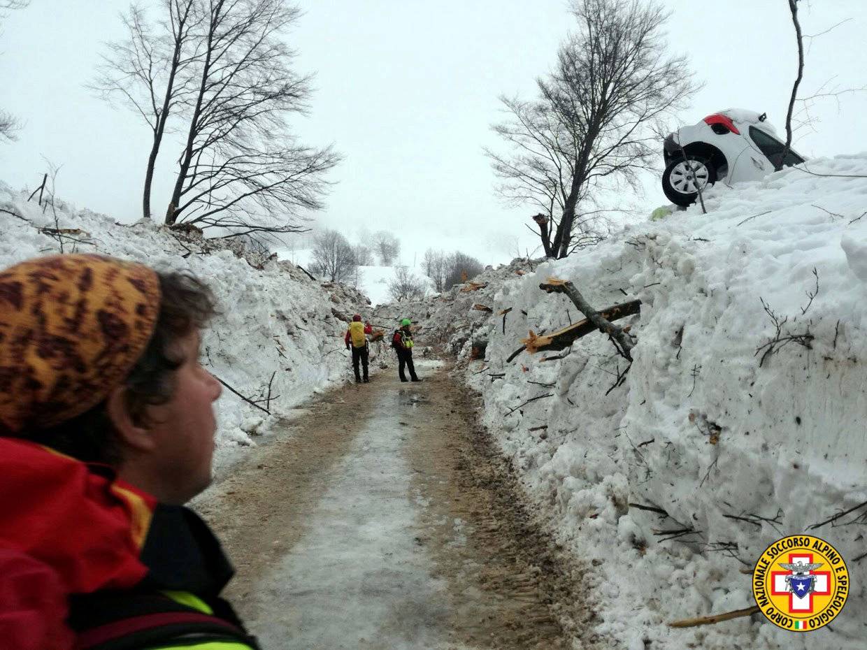 Rescue workers inspect a cleared road by the site of the avalanche-buried Hotel Rigopiano in Farindola