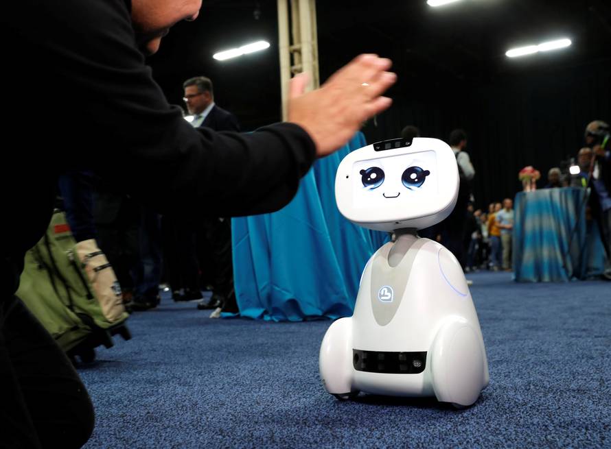 Buddy, an entertainment and assistant robot by Blue Frog Robotics, interacts with a attendee during CES Unveiled at the 2018 CES in Las Vegas