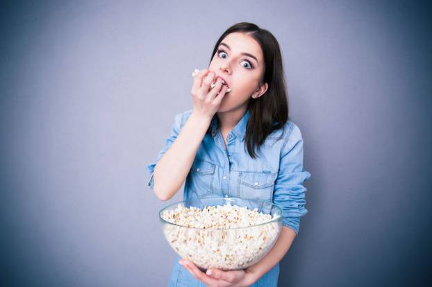 Young cute woman eating popcorn