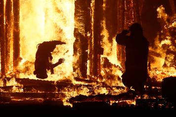 Burning Man participant runs into the flames of the "Man Burn" at the Burning Man arts and music festival in the Black Rock Desert of Nevada