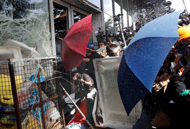 Riot police use pepper spray as protesters try to break into the Legislative Council building during the anniversary of Hong Kong