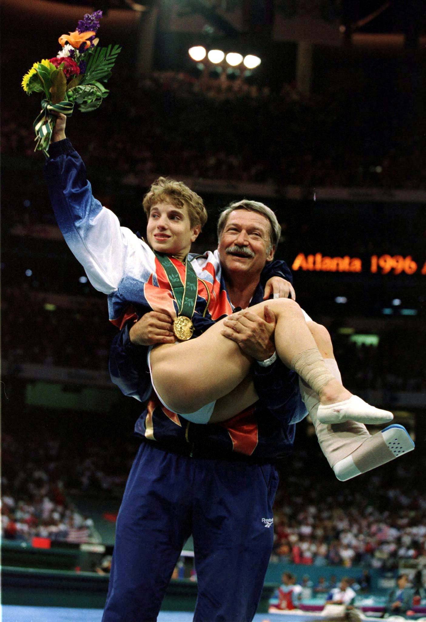 FILE PHOTO: Unofficial USA Women Gymnastics Coach Lifts Kerry Strug In The Air After Olympic Win