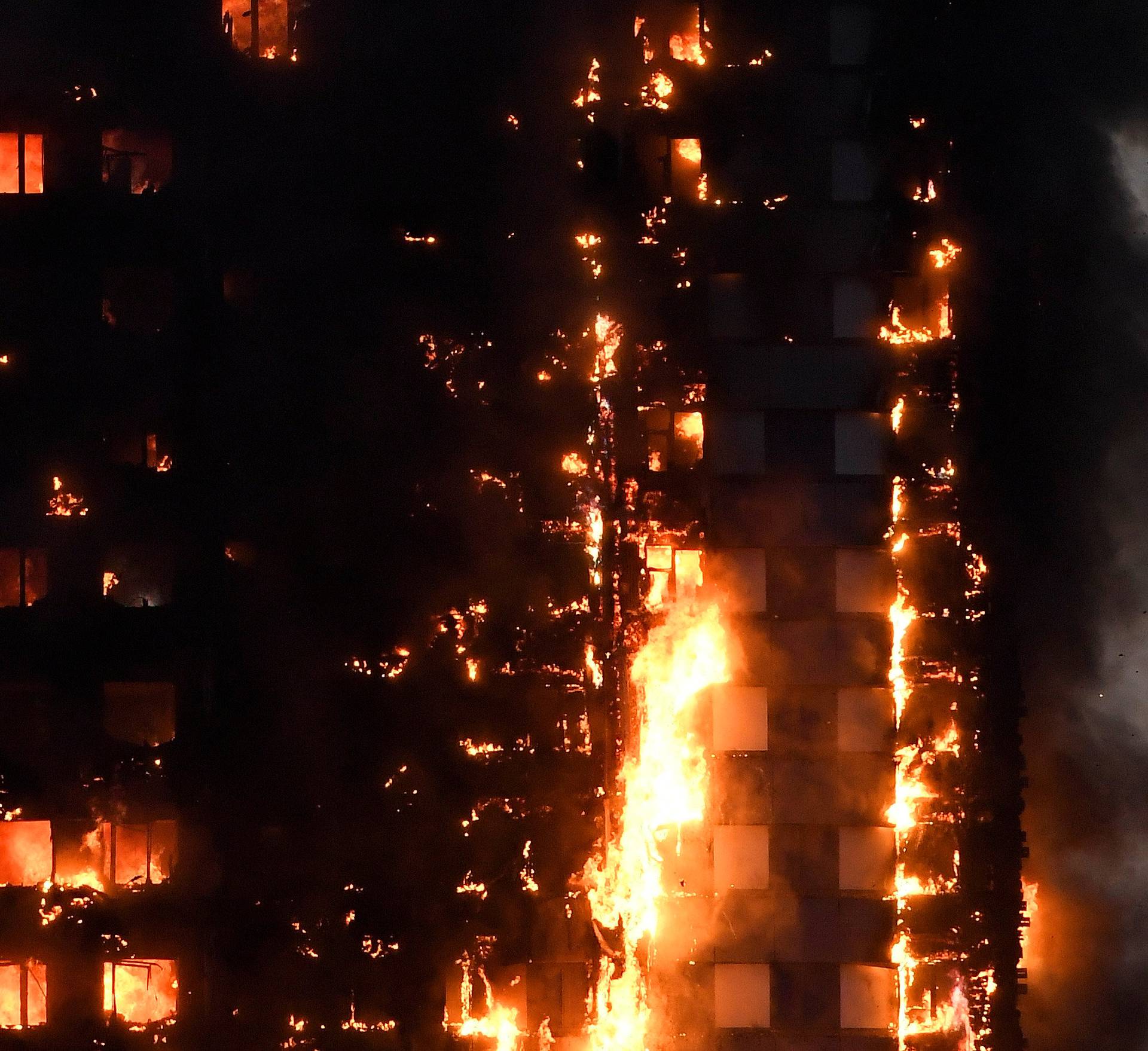 Flames and smoke billow as firefighters deal with a serious fire in a tower block at Latimer Road in West London