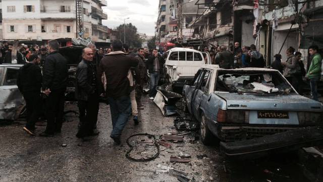 People inspect the damage at the site of a car bomb explosion, in the centre of the Syrian town of Jableh in the coastal Mediterranean province of Latakia