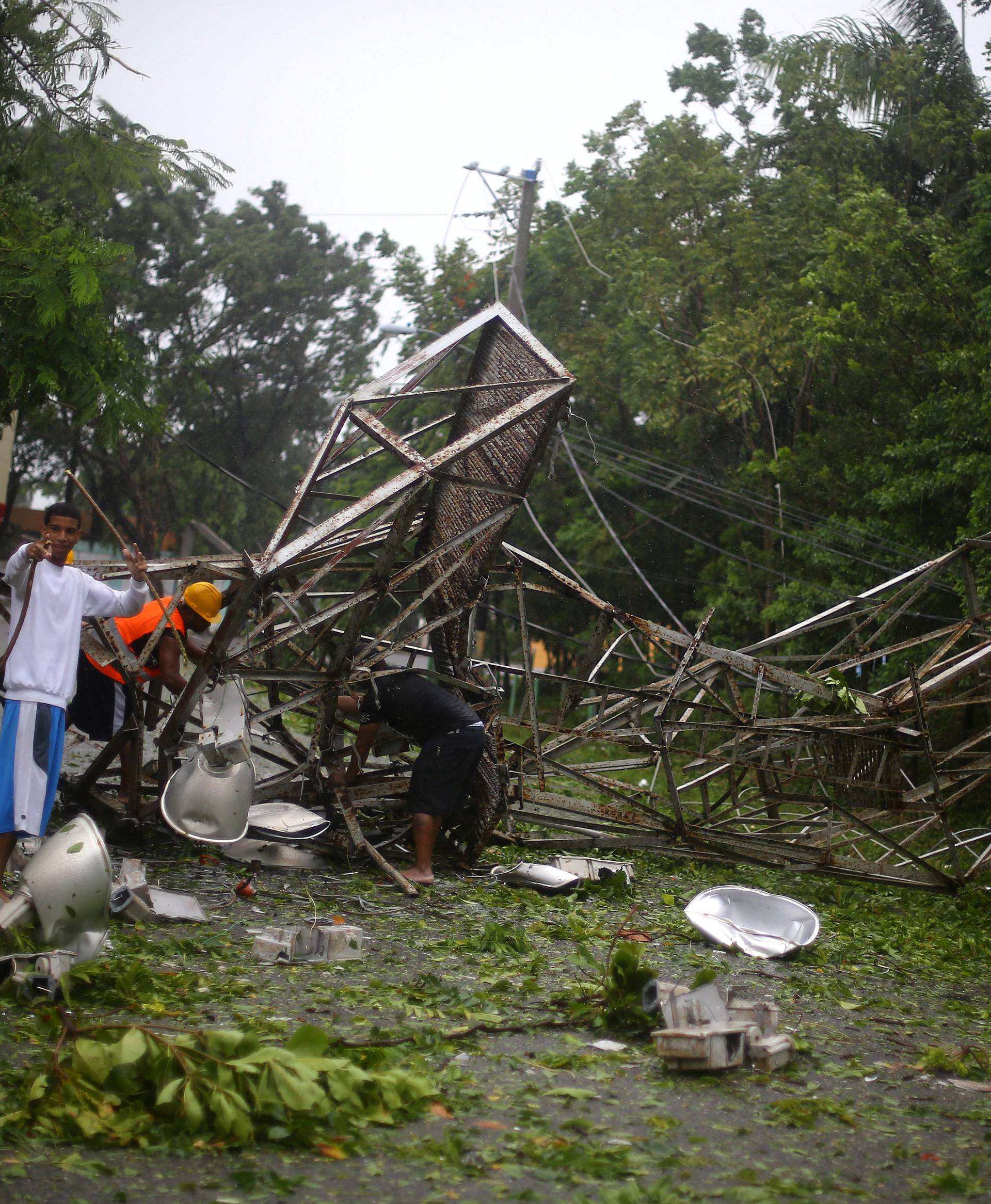 Locals remove pieces from a fallen stadium lighting tower as Hurricane Irma moves off the northern coast of the Dominican Republic, in Puerto Plata