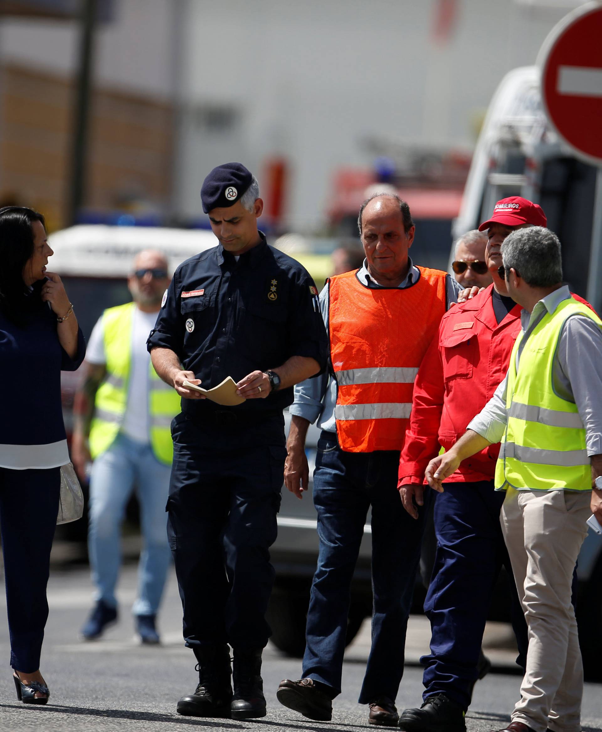 Members of civilian protections leave the site where a small airplane crashed, near a supermarket in a residential area outside Lisbon, Portugal