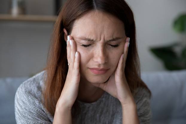 Tired unwell woman suffer from headache at home