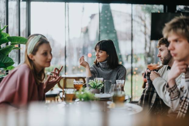 Group of friends enjoying conversation over drinks in a cozy cafe