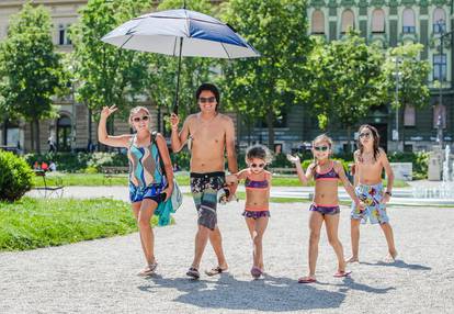 Ljeto je stiglo - pokazala je ova nasmijana  obitelj prošavši centrom grada u kupaćim kostimima 