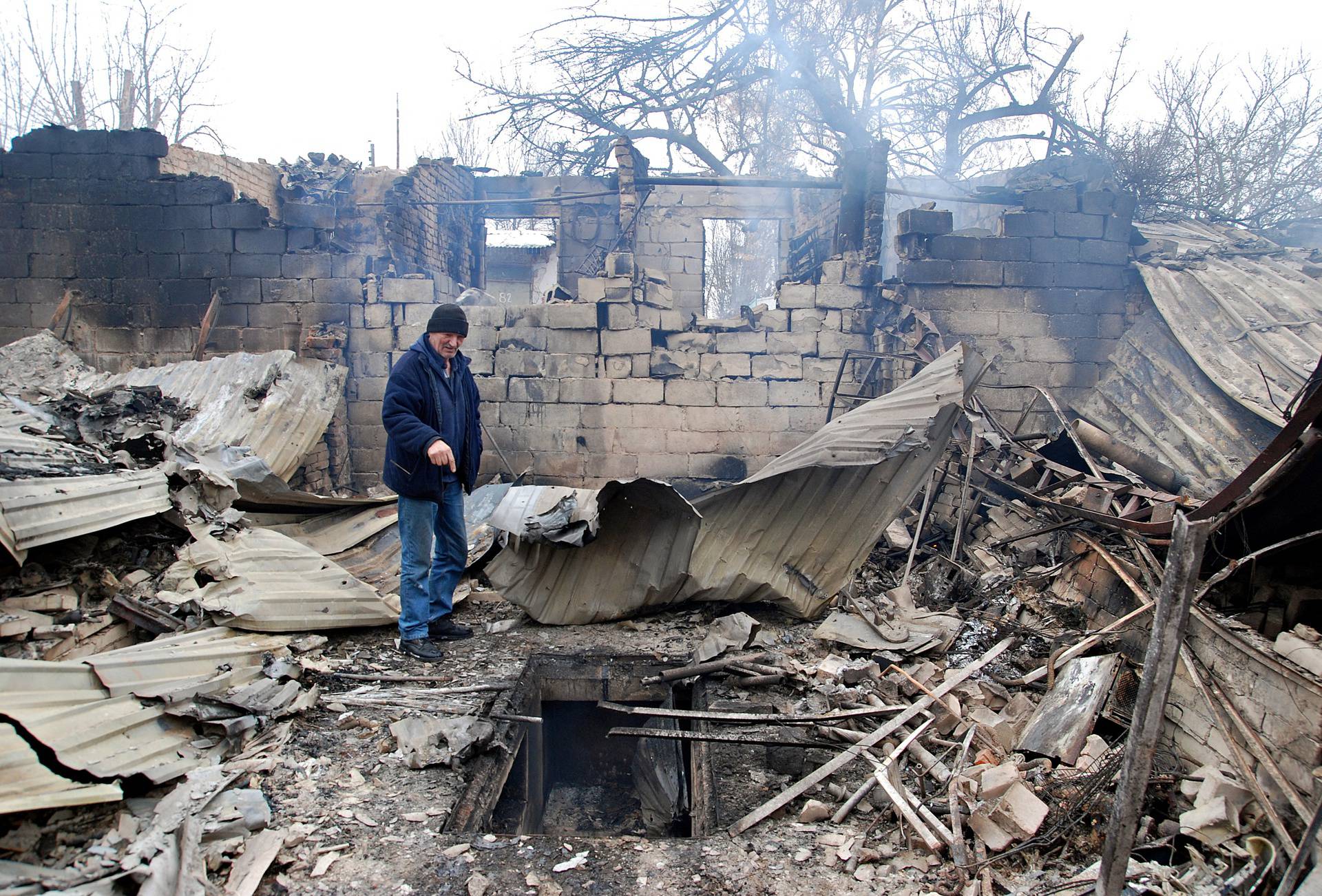 A man stands on the rubble of a house destroyed by recent shelling during Ukraine-Russia conflict in Kharkiv