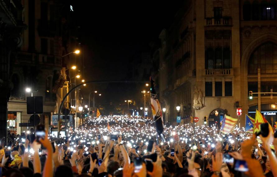 Demonstrators hold up their phones during a protest after a verdict in a trial over a banned independence referendum, in Barcelona