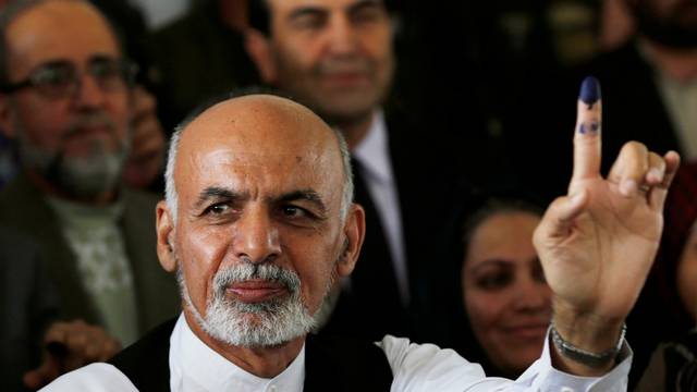 FILE PHOTO: Afghan presidential candidate Ashraf Ghani Ahmadzai holds up his ink-stained finger after voting in the presidential election in Kabul