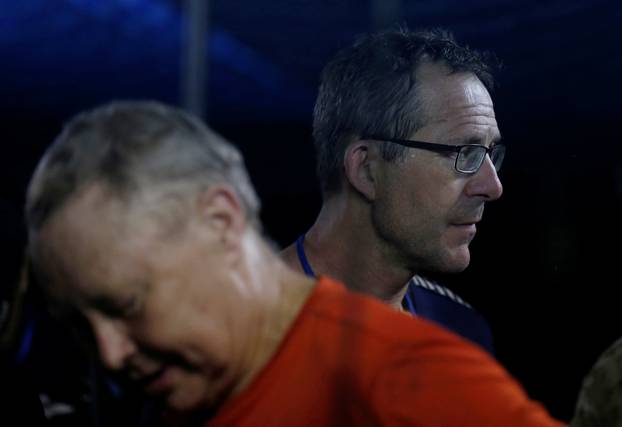 British divers Robert Charles Harper and John Volanthen chat with a military officer from Thailand near the Tham Luang cave complex, in the northern province of Chiang Rai