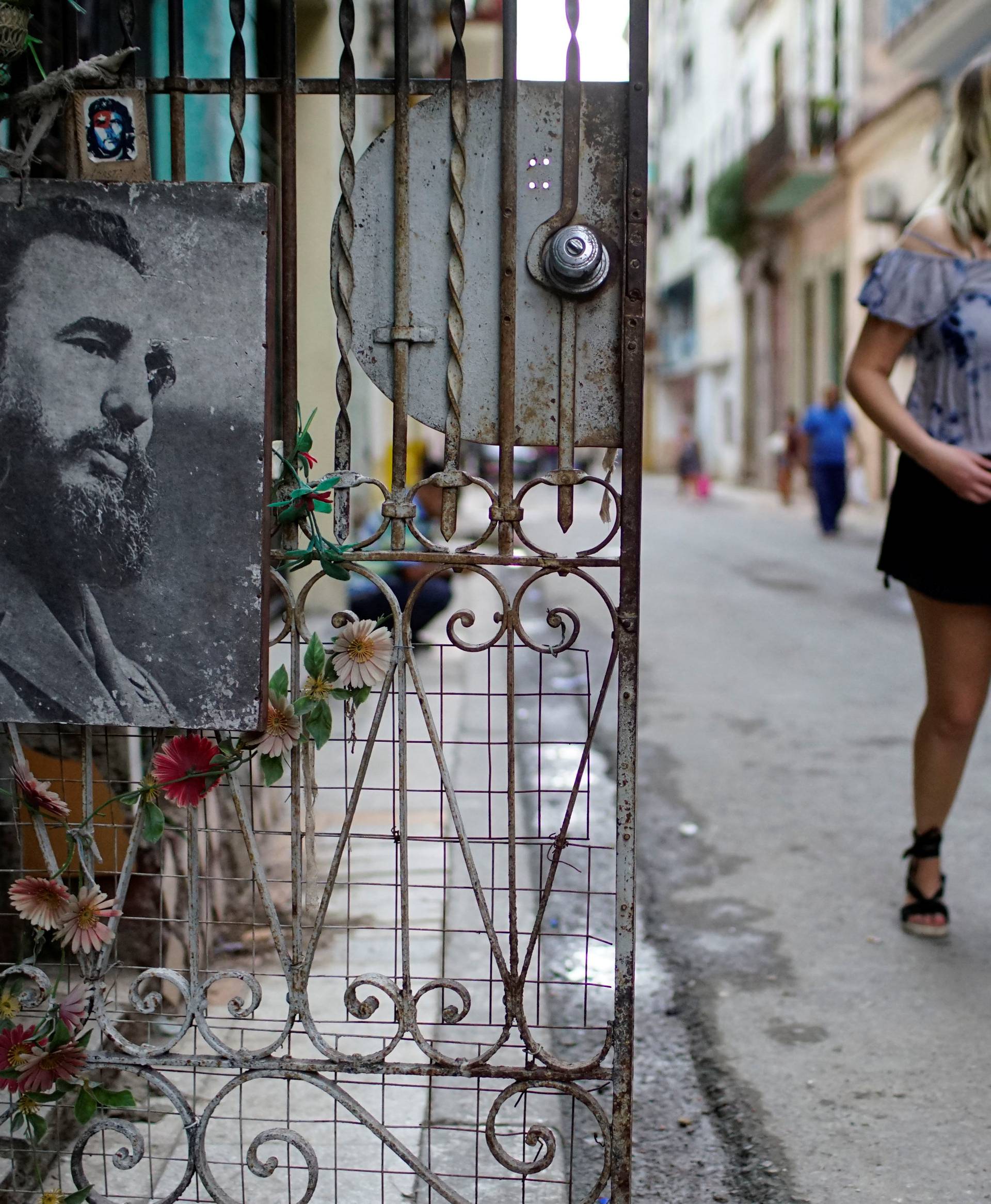 Tourists walk past an image of Cuba's late president Fidel Castro in downtown Havana