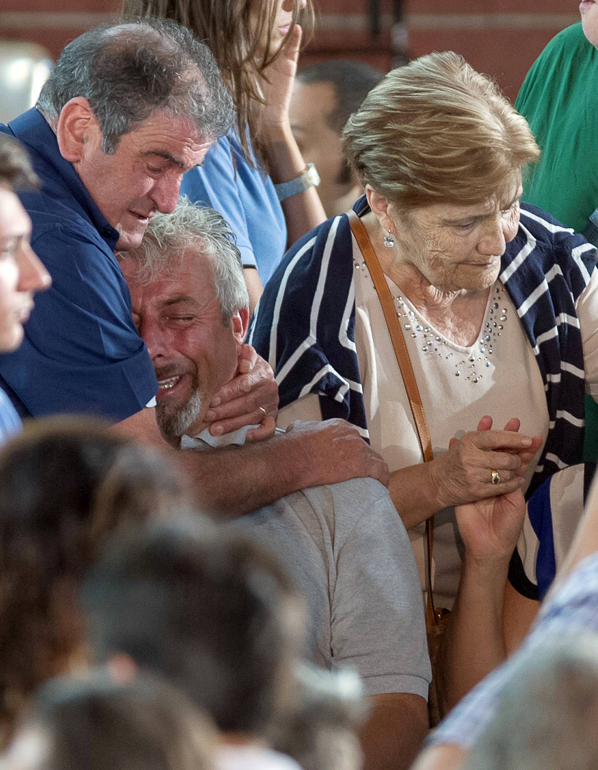A man cries after a funeral service for victims of the earthquake inside a gym in Ascoli Piceno, Italy