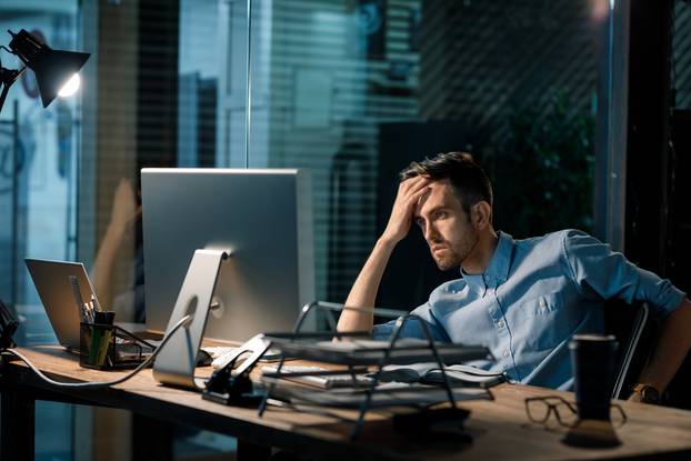 Man,Sitting,Alone,In,Office,Late,At,Night,Watching,Computer