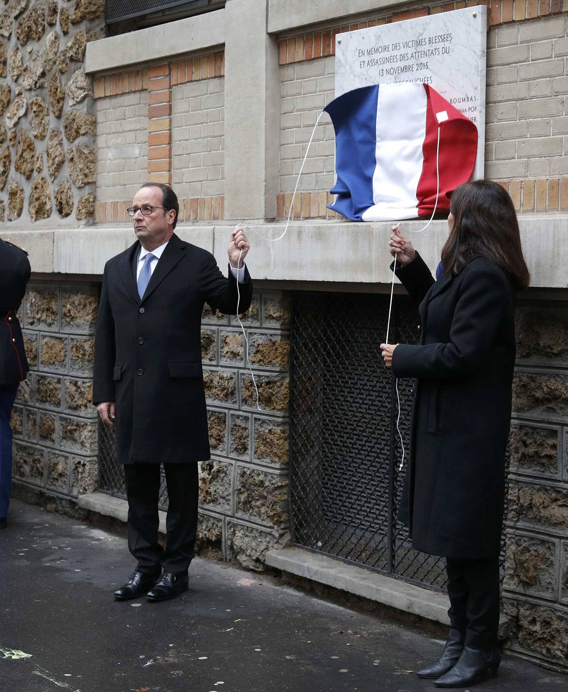 French President Francois Hollande and Paris Mayor Anne Hidalgo unveil a commemorative plaque next to the "La Belle Equipe" bar and restaurant in Paris