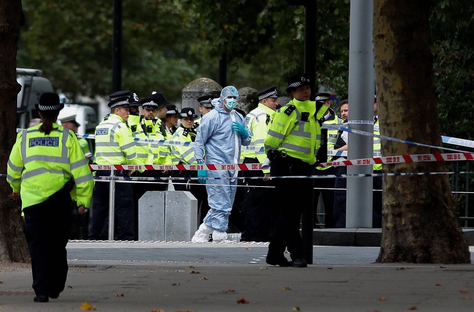Police and forensic officers gather in the road near the Natural History Museum, after a car mounted the pavement, in London