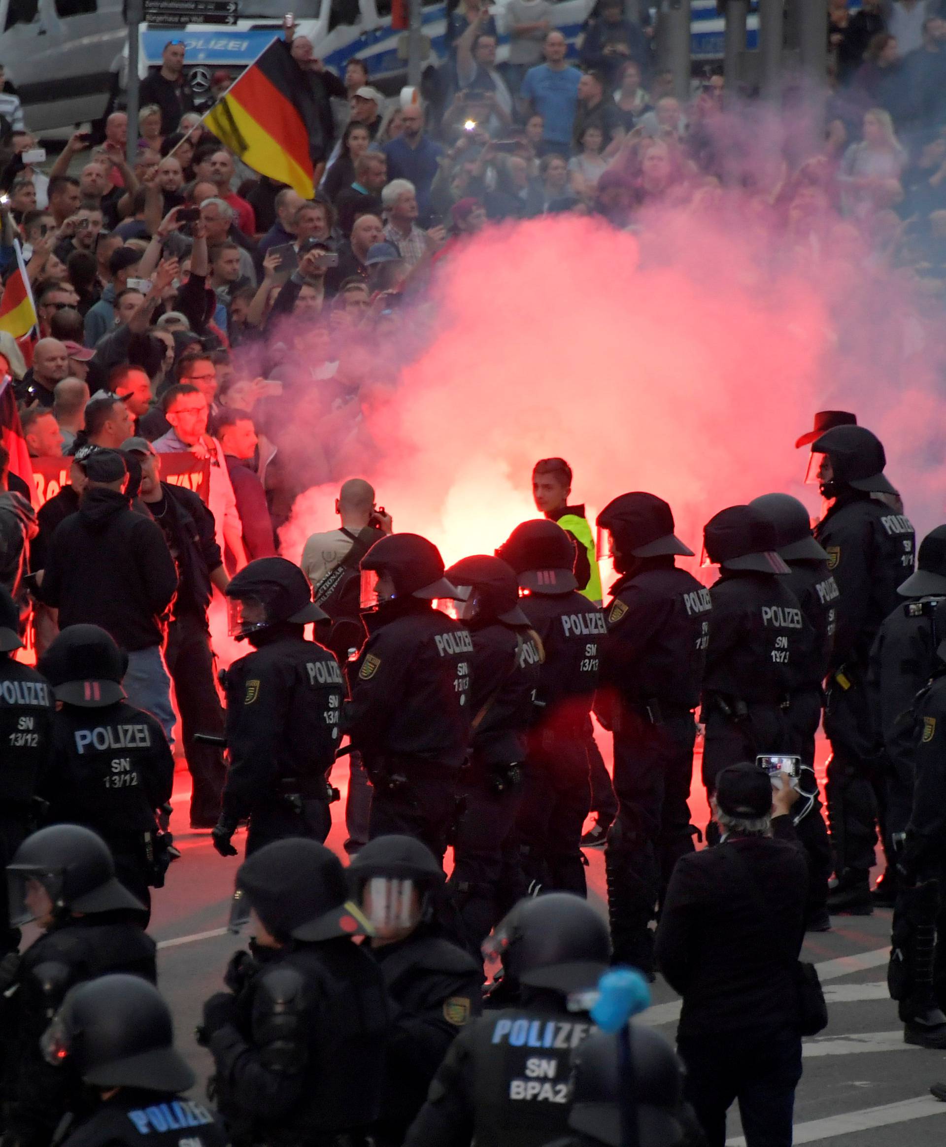 Riot policemen stand guard as the right-wing supporters protest after a German man was stabbed last weekend in Chemnitz