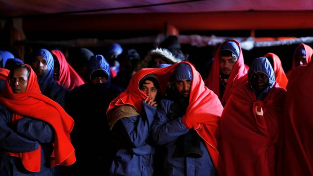 Migrants wait to disembark from a rescue boat at the port of Malaga