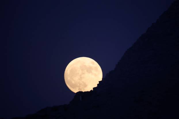 Full moon rises behind the Pyramids of Giza in Egypt