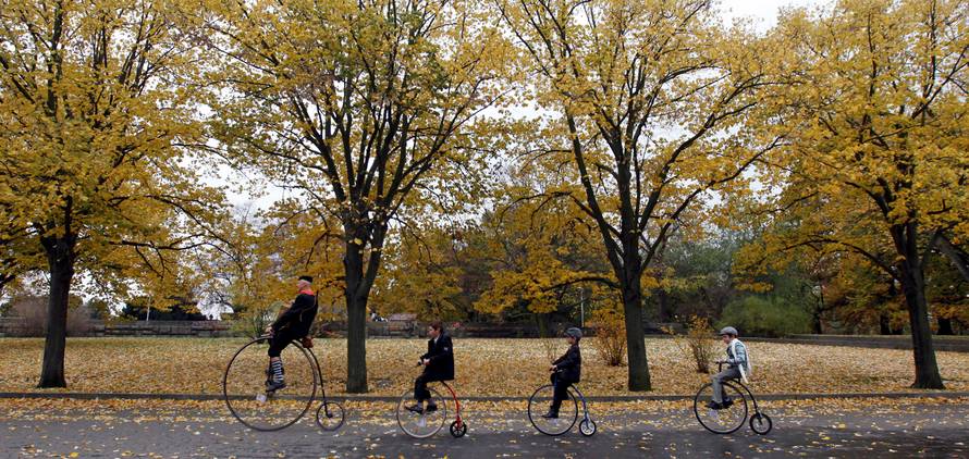 Participants wearing historical costumes ride their high-wheel bicycles during the annual penny farthing race in Prague