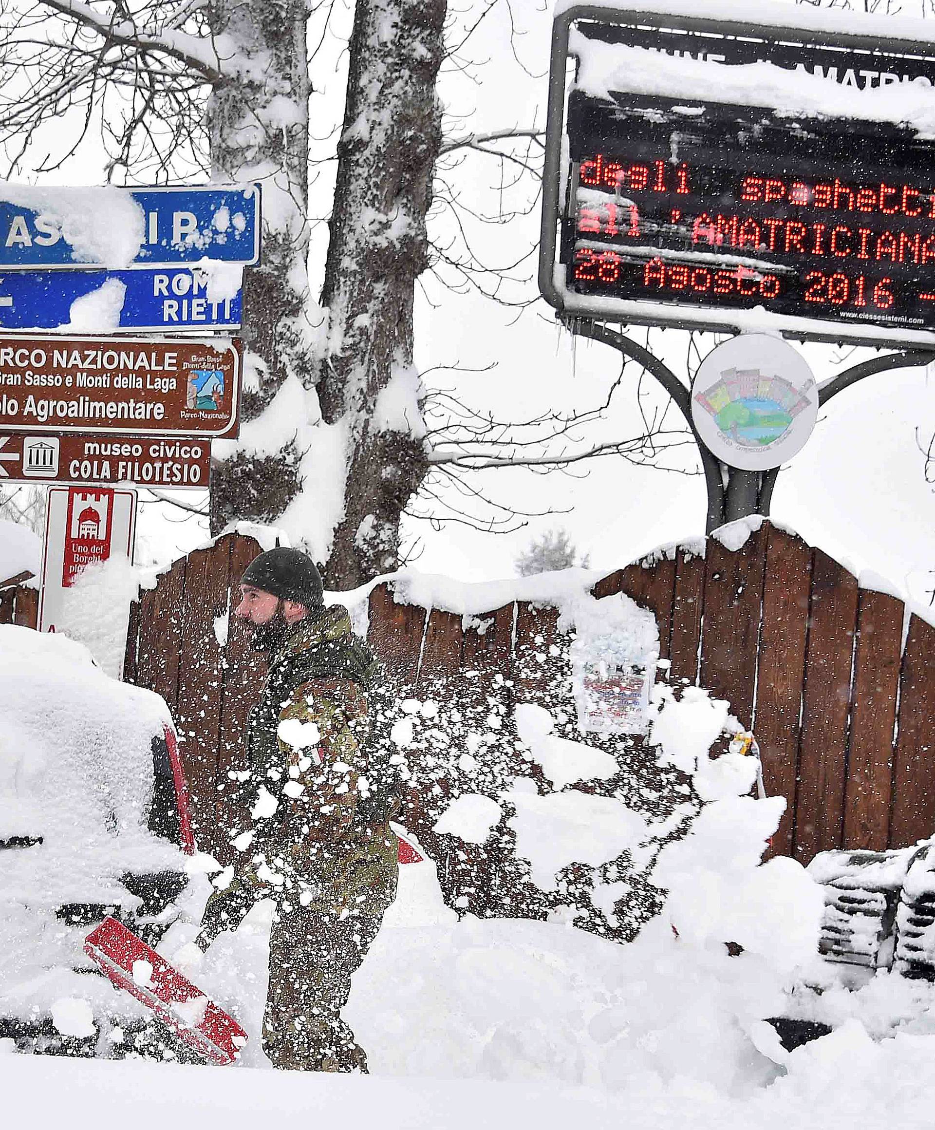 A soldier removes snow in Amatrice, after a series of earthquakes hit the town and parts of central Italy