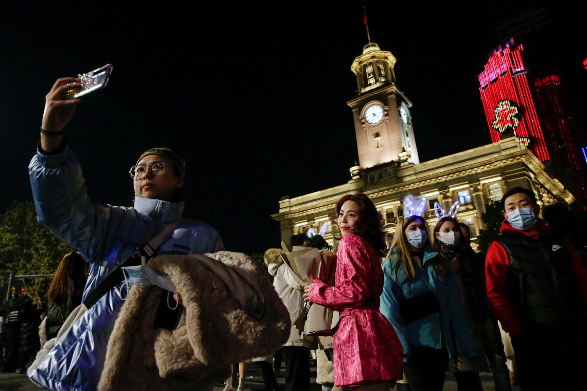 People pose for a selfie as they celebrate the arrival of the new year in Wuhan