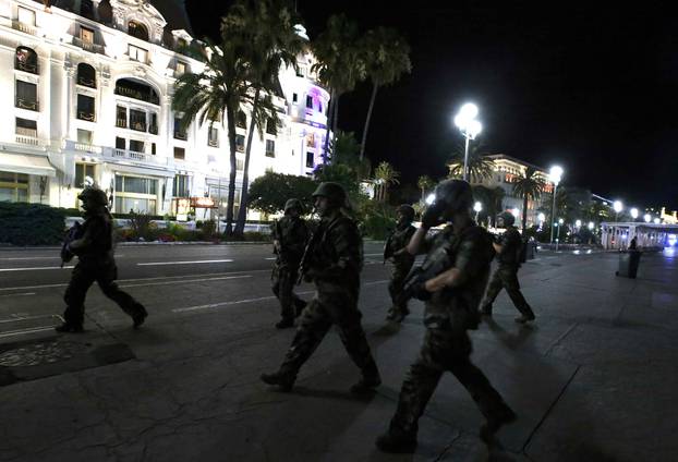 French soldiers advance on the street after at least 30 people were killed in Nice, France, when a truck ran into a crowd celebrating the Bastille Day national holiday