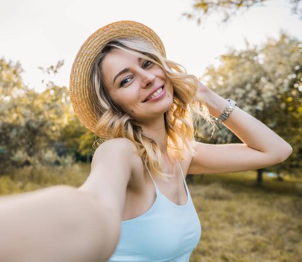 Stylish modern girl taking a selfie out in the park.