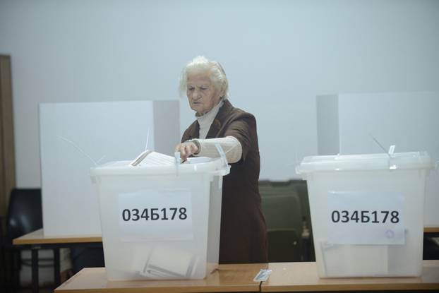 A woman casts her ballot during presidential and parliamentary elections at a polling centre in a school in Banja Luka