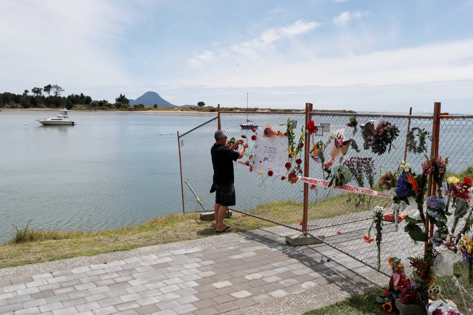 A man contributes to a memorial at the harbour in Whakatane, following the White Island volcano eruption in New Zealand