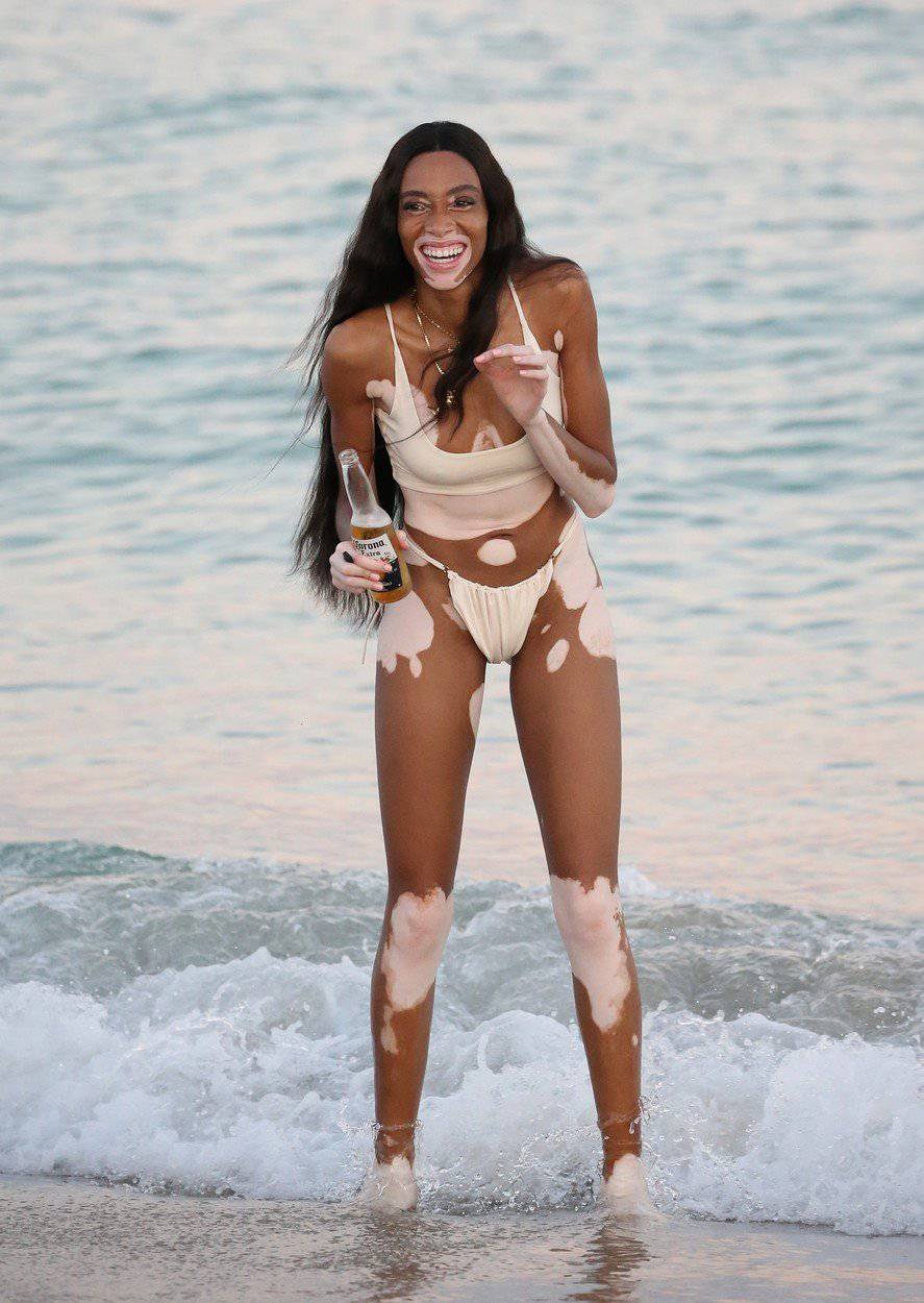 Supermodel Winnie Harlow wears a teeny white bikini as she goes for a swim with friends on the beach in Miami