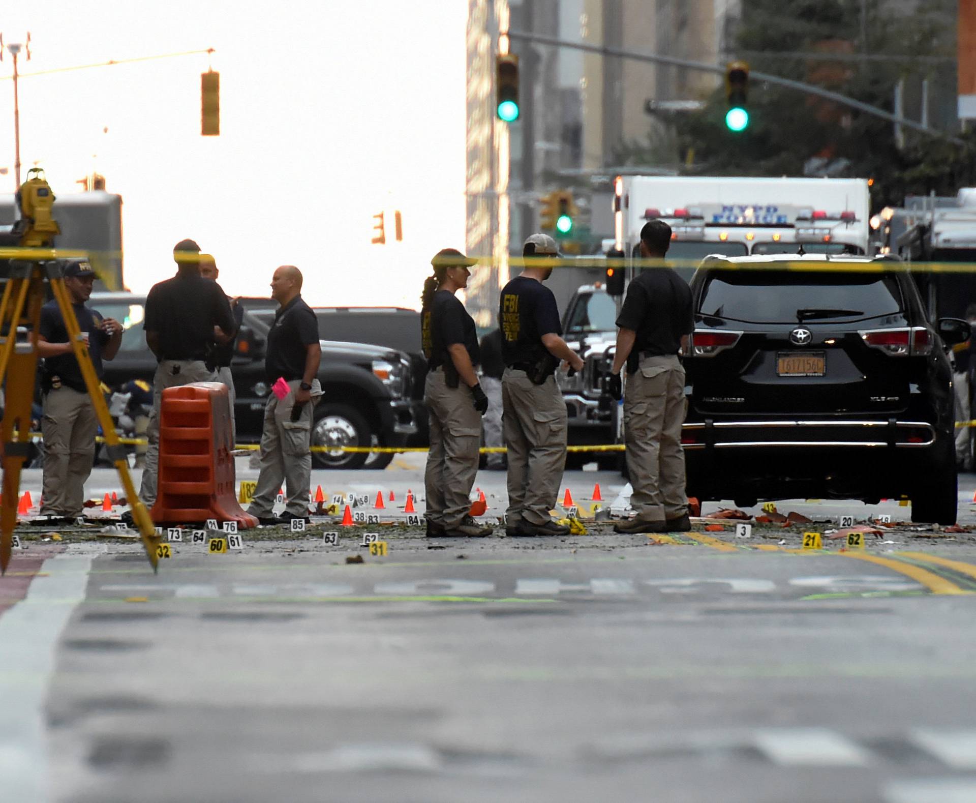 Evidence markers on the street surround FBI officials near site of  explosion in New York