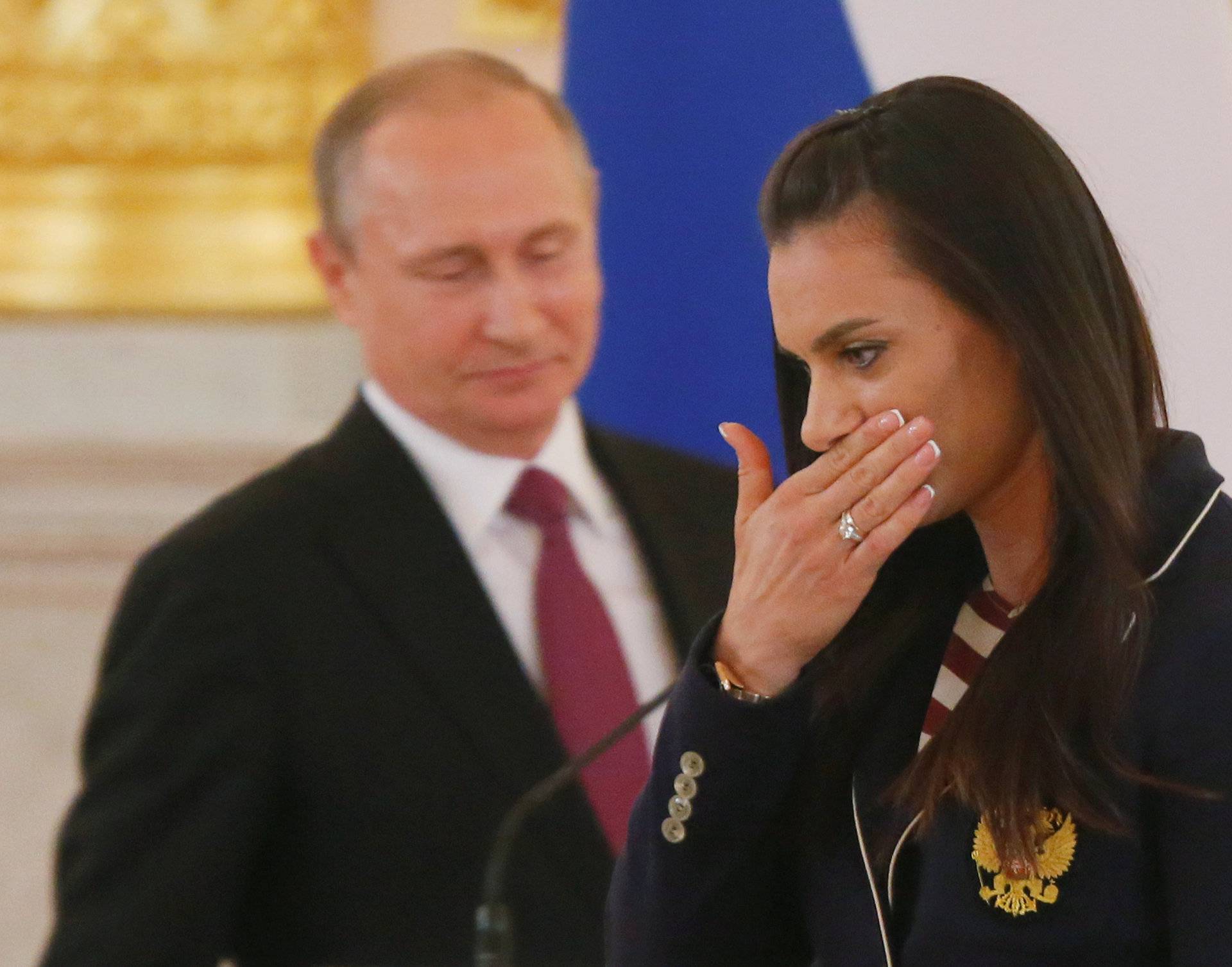 Track-and-field athlete Isinbayeva reacts as she walks past Russian President Putin during his personal send-off for members of the Russian Olympic team at the Kremlin in Moscow