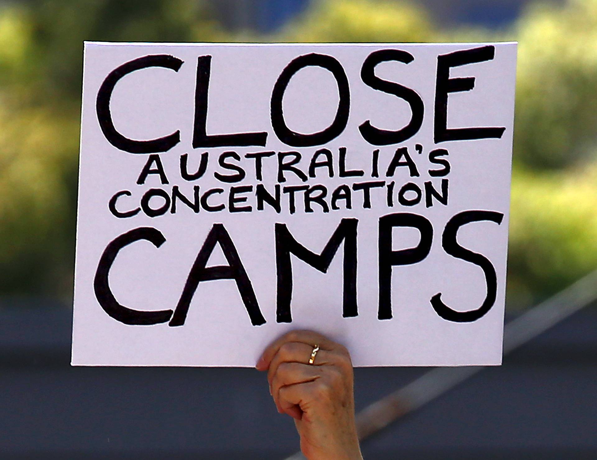 A protester holds a placard during a rally in support of refugees in central Sydney, Australia
