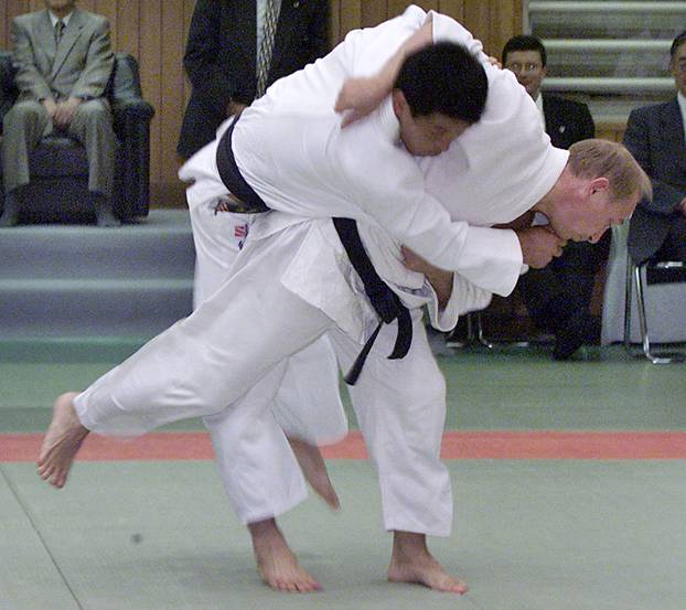 FILE PHOTO: Russian President Vladimir Putin (R) throws a Japanese judo expert during a judo demonstration at the Kodokan in Tokyo