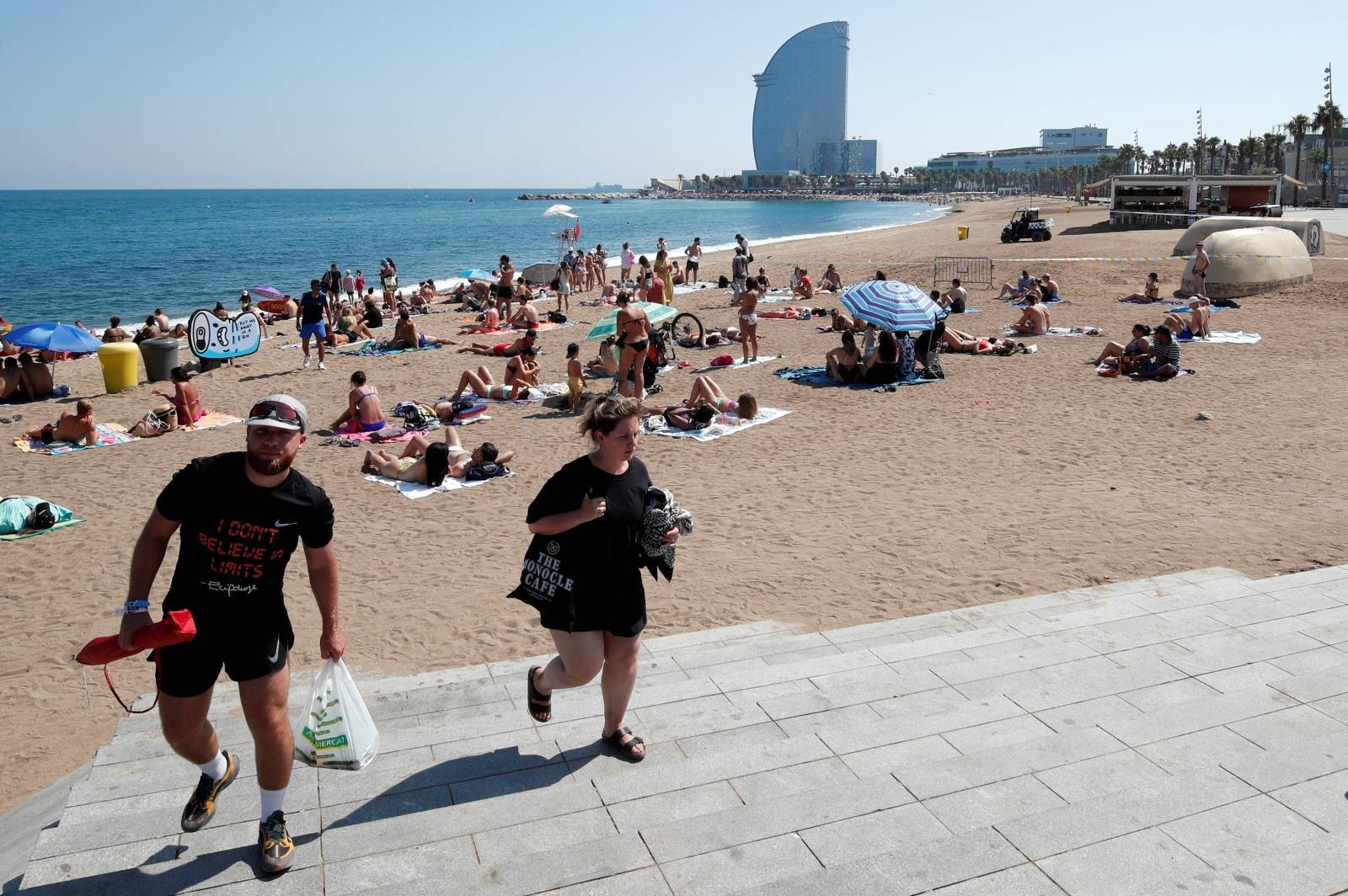 People leave Sant Sebastia beach after police found an explosive device in the water and evacuated part of it, in Barcelona