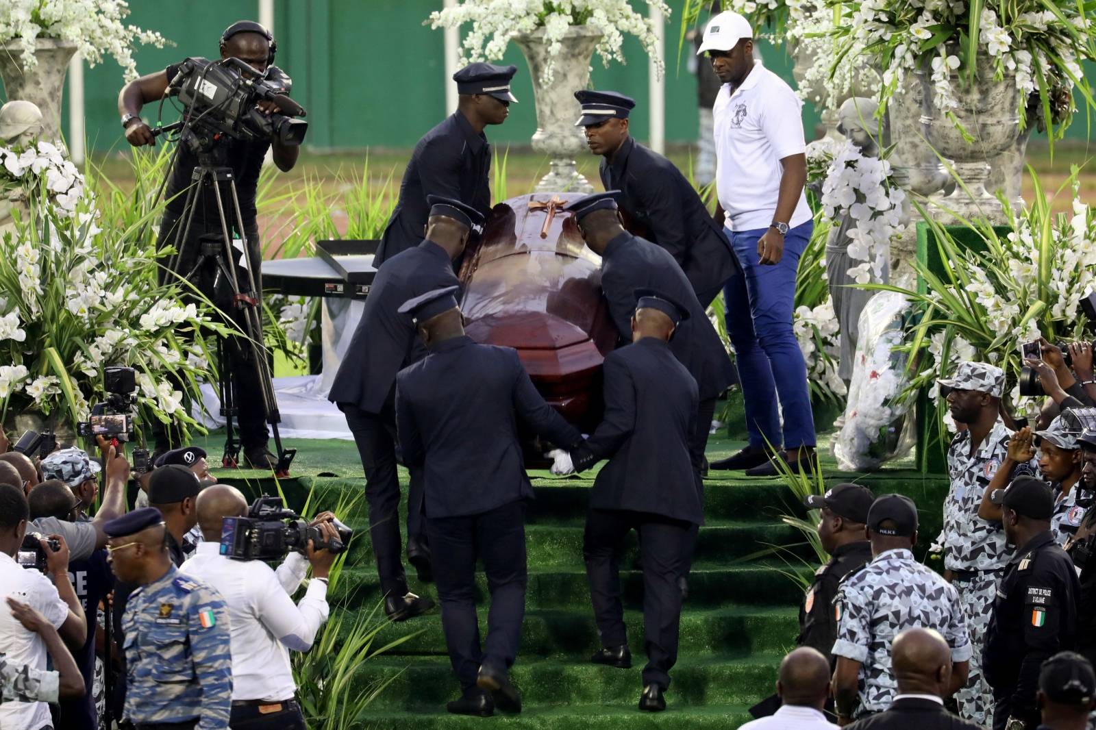 Men carry the casket of Ange Didier Houon, known as DJ Arafat, during his funeral ceremony in Abidjan