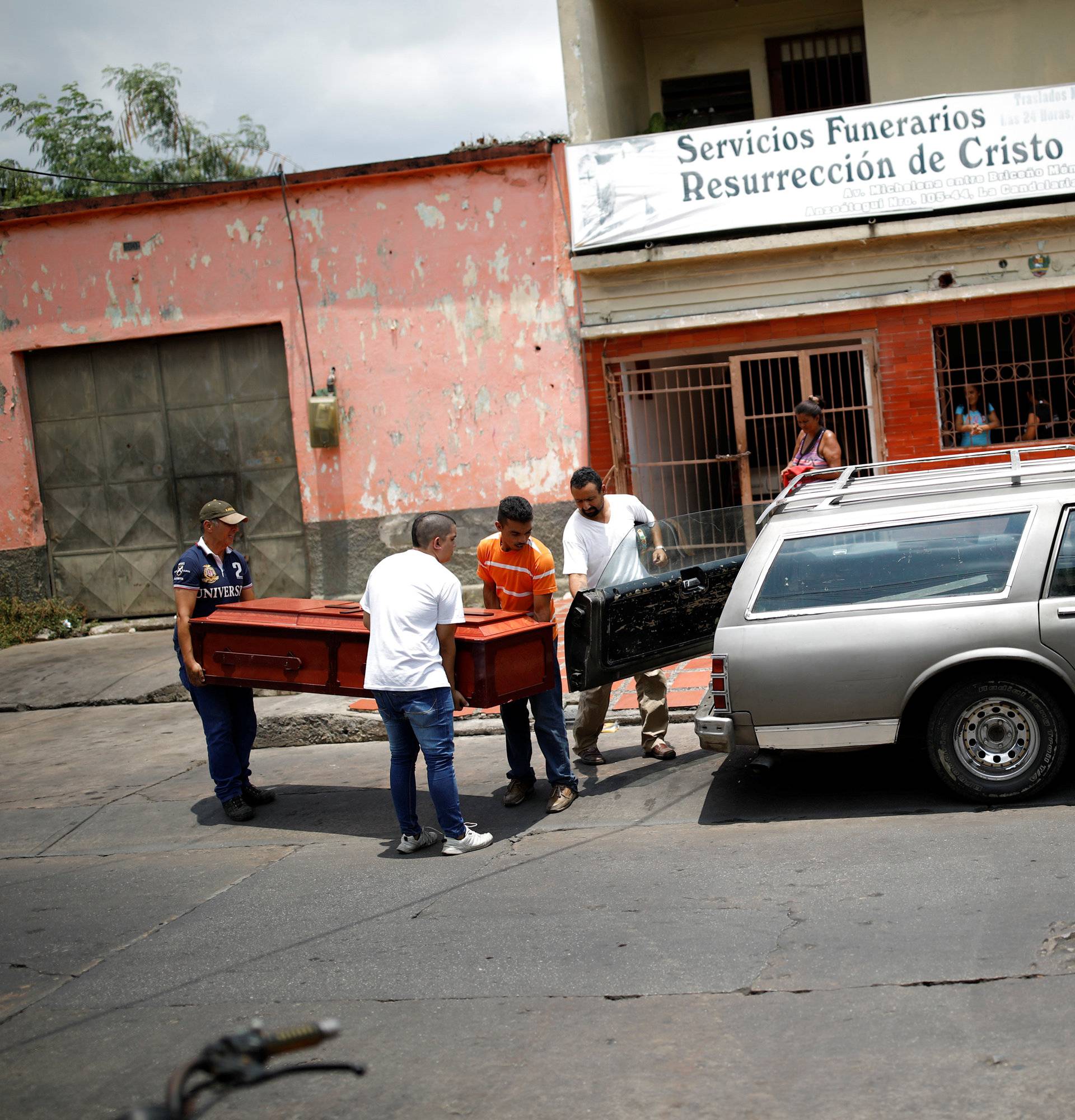 Men carry the coffin of Javier Rivas, one of the inmates who died during a riot and fire in the cells of the General Command of the Carabobo Police, at a funeral home in Valencia